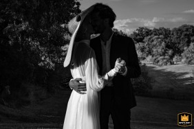 At Chateau de Lartigolle in Auch, France, a couple is captured in black and white, their faces cast in shadows from her oversized fascinator hat.